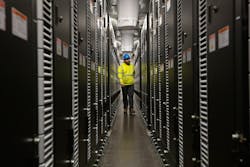 Kyle Murray, NYPA Construction Engineer, walks through one of the battery units at the Northern New York battery storage project, with construction completed. The Willis substation is adjacent to the facility.