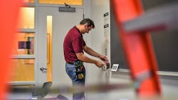 Photo 3. Maintenance worker adjusts a wall control device.