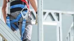 A construction worker with fall protection gear