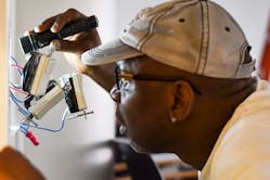 An electrician installs AC-powered controls in an NGLS living lab