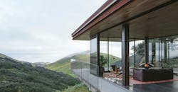 Photo 1. This structure in Central Coast, Calif. is powered by an array of 28 solar panels situated down the hill from the guesthouse to preserve views extending out into the ocean. The panels sit along the grade of the hill to maximize exposure to the sun. The conduit is run underground to the garage where the batteries and inverter live.